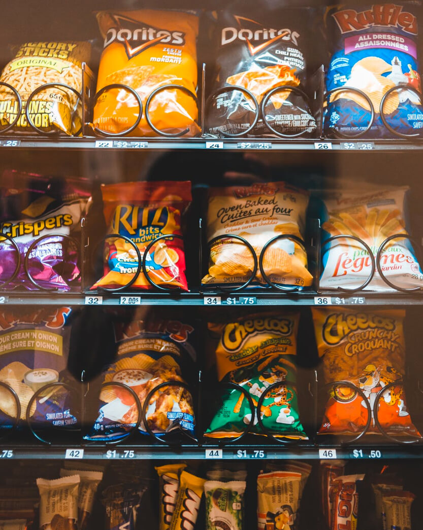 Rows of snacks and treats inside of a vending machine.